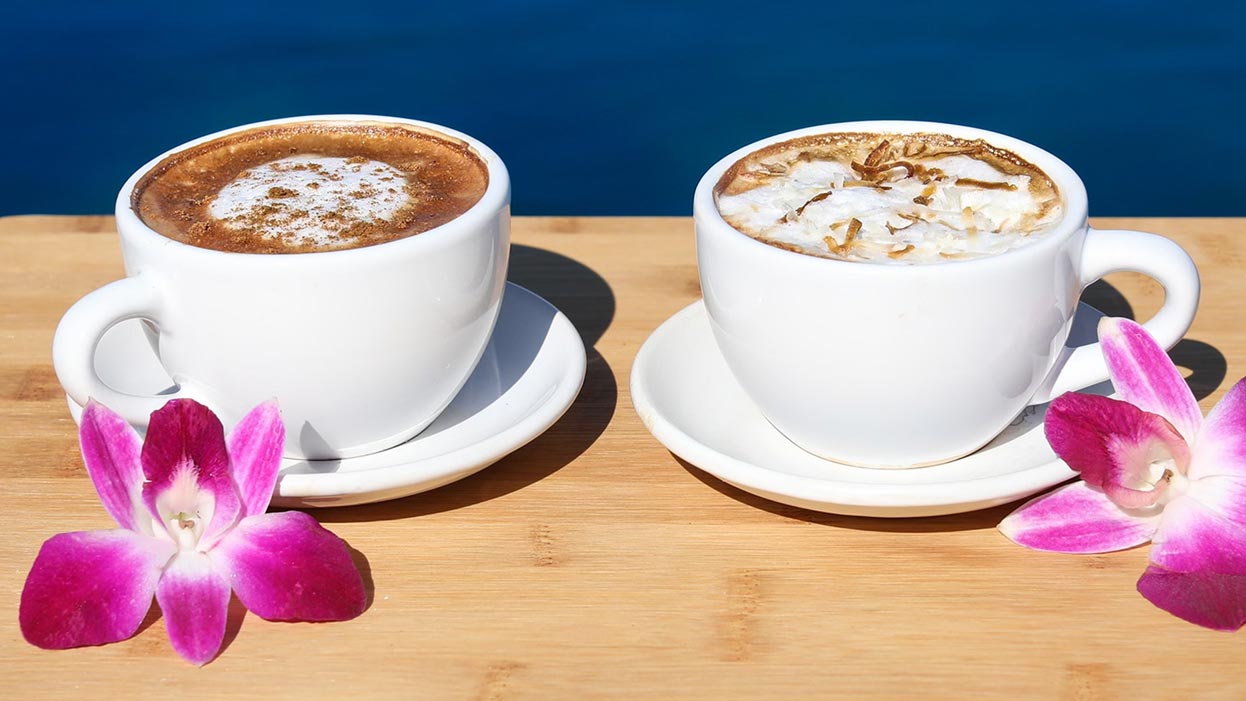 two cups of espresso decorated with orchids
