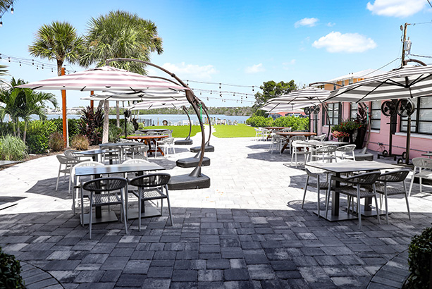 tables with umbrellas on a paver patio overlooking Lemon Bay