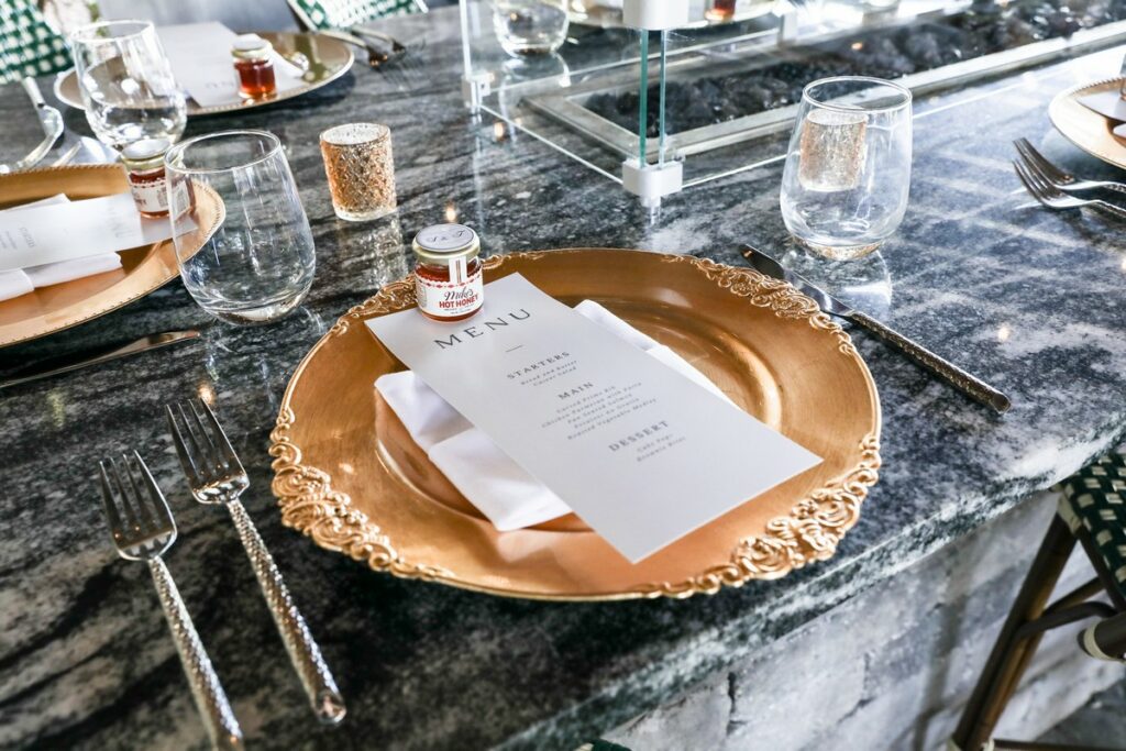 place setting with menu card and party favor on a gold charger plate